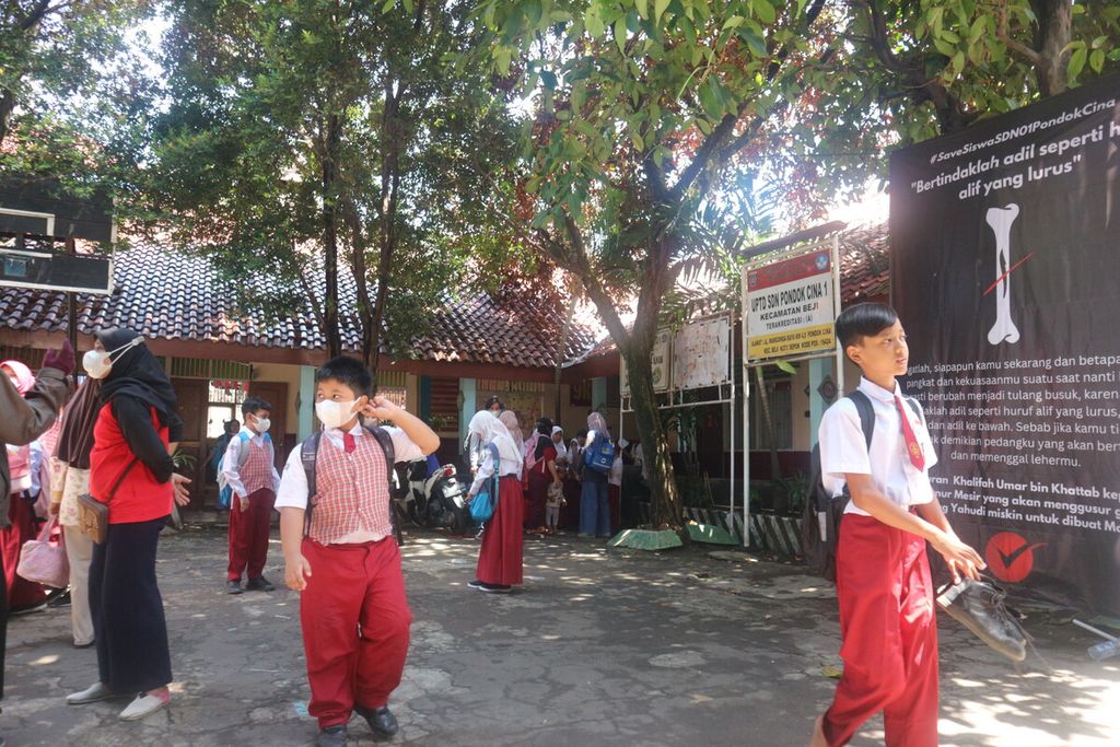 Murid SDN Pondok Cina 1 sedang berada di halaman sekolah tersebut setelah mengikuti pelajaran yang diajarkan relawan dari komunitas masyarakat dan mahasiswa, Rabu (30/11/2022).