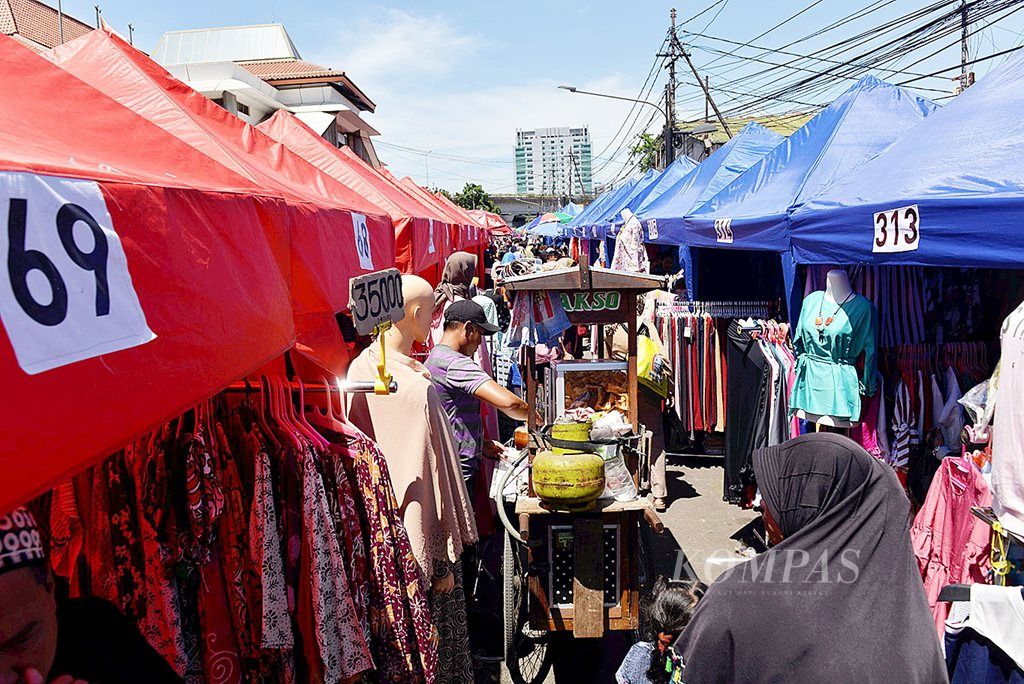 Warga melihat dagangan pedagang kaki lima (PKL) di tenda-tenda di salah satu ruas Jalan Jatibaru Raya, Jakarta Pusat, Senin (25/12). Meski telah disediakan tenda untuk berjualan, trotoar di jalan tersebut belum sepenuhnya bersih dari PKL yang berdagang.