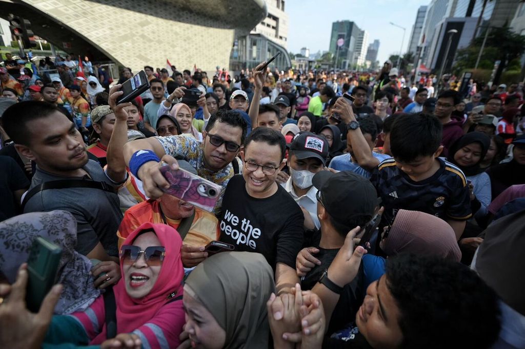 Mantan Gubernur DKI Jakarta Anies Baswedan tengah berfoto bersama dengan masyarakat pada hari bebas kendaraan bermotor (<i>car free day</i>) di kawasan Sudirman-Thamrin, Jakarta, Minggu (1/9/2024).