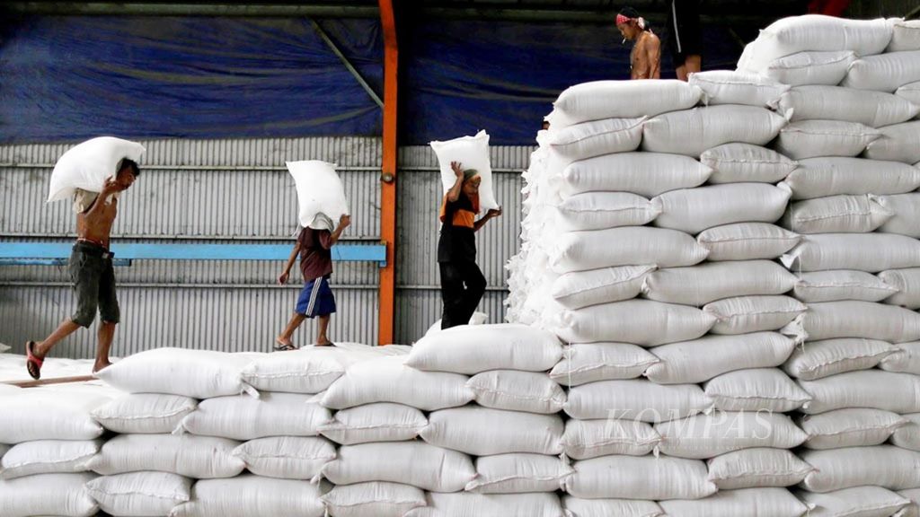 Buruh memasukkan beras yang baru tiba dari Sulawesi Selatan ke dalam gudang Bulog di kawasan Kelapa Gading, Jakarta.