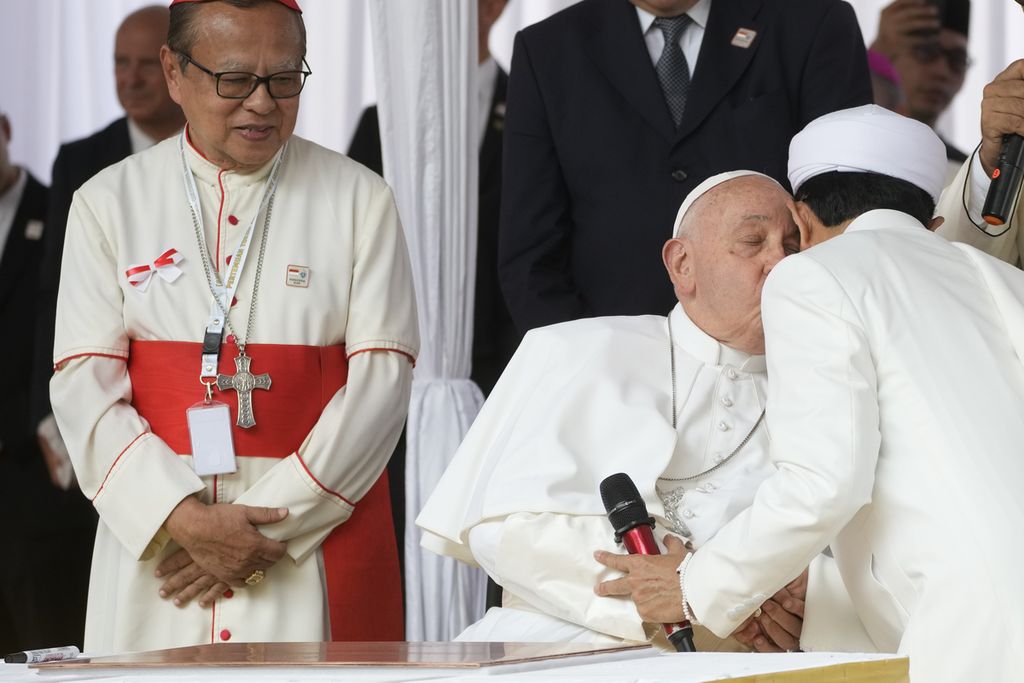 Paus Fransiskus, didampingi Uskup Agung Jakarta Kardinal Ignatius Suharyo Hardjoatmodjo (kiri), mencium Imam Besar Masjid Istiqlal Nasaruddin Umar (kanan) setelah menandatangani deklarasi dalam kunjungan ke Terowongan Silaturahim, yang menghubungkan Masjid Istiqlal dan Katedral Santa Maria Diangkat ke Surga, di Jakarta, Kamis (5/9/2024). 