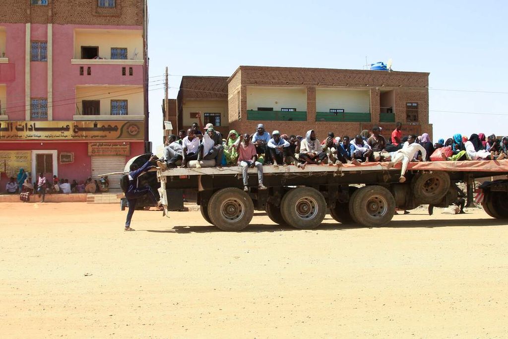 Sejumlah warga berusaha keluar dari Khartoum  di Sudan, 21 April 2023. Pertempuran sengit antara dua faksi militer telah menewaskan lebih dari 400 orang dan melukai ribuan orang. Ribuan warga kota Khartoum berusaha mengungsi keluar kota. (Photo by Ebrahim Hamid / AFP)