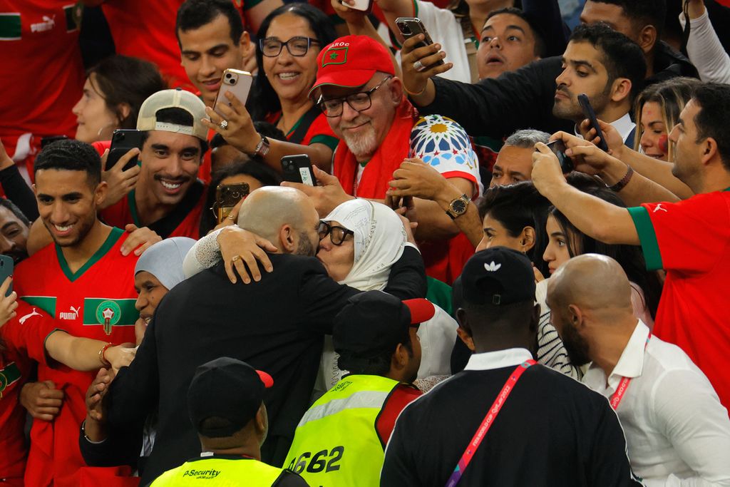 Pelatih Maroko Walid Regragui (tengah kiri) memeluk ibunya setelah Maroko mengalahkan Portugal, 1-0, pada laga perempat final Piala Dunia Qatar 2022 di Stadion Al-Thumama, Doha, 10 Desember 2022. Kemenangan itu menjadikan Maroko tim asal Afrika pertama yang lolos ke semifinal Piala Dunia. 