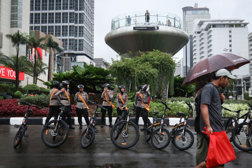 Para polwan berjaga saat hari bebas kendaraan bermotor (HBKB) di kawasan Bundaran HI, Jakarta, Minggu (12/2/2023). 
