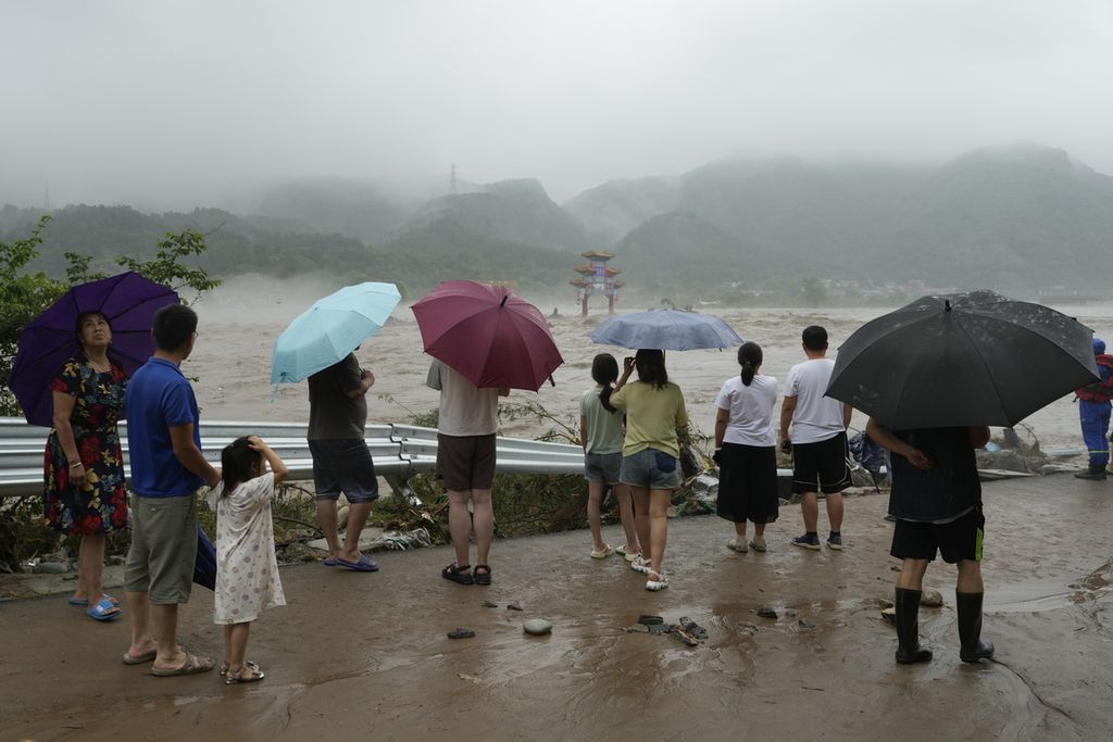 Warga melihat ke area yang tergenang banjir di Miaofengshan, pinggiran Beijing, China, Selasa (1/8/2023). 