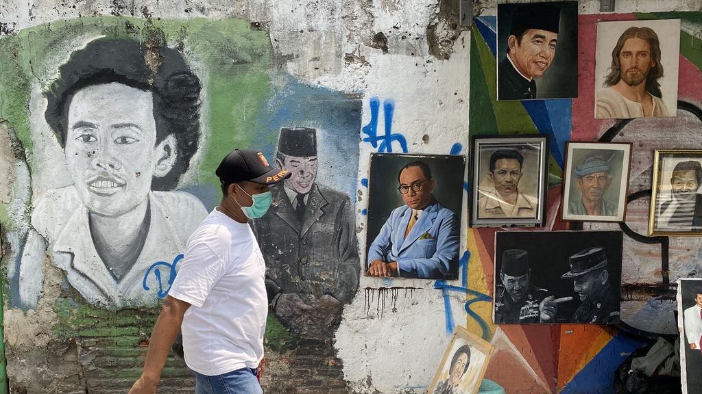 Warga melintasi mural potret penyair dan aktivis HAM Wiji Thukul di kawasan Kota Tua, Jakarta, Sabtu (25/7/2020). Mural Wiji Thukul karya pelukis Bagong Surono dibuat untuk mengapresiasi semangat perlawanan dan perjuangan Wiji Thukul terhadap penindazan rezim Orde Baru. 