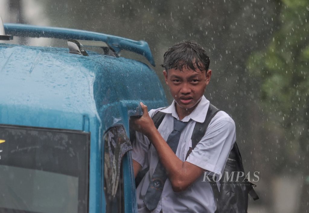 Siswa SMP pulang sekolah naik angkot saat hujan deras mengguyur kawasan Ciampea, Bogor, Jawa Barat, Selasa (14/11/2023). Berdasarkan prakiraan Badan Meteorologi, Klimatologi, dan Geofisika, sejumlah wilayah Jabodetabek  memiliki periode awal musim hujan bervariasi.