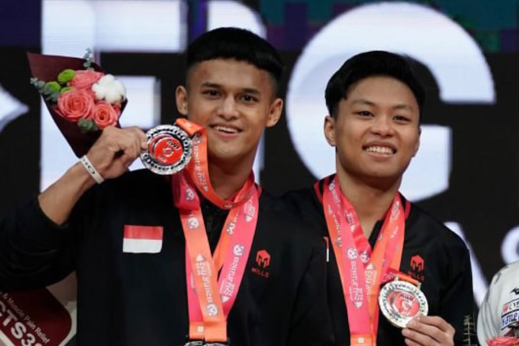 Lifter Indonesia, Rahmat Erwin Abdullah (kanan) dan Rizki Juniansyah, berpose setelah memborong enam medali di Kejuaraan Angkat Besi Asia 2024 di Uzbekistan, Selasa (6/2/2024). Rahmat dan Rizki bersaing untuk meraih satu tiket ke Olimpiade Paris 2024.