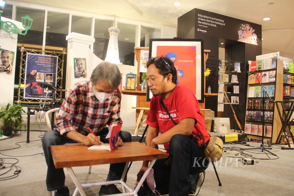 Penyair Joko Pinurbo menandatangani buku kumpulan puisi karyanya yang berjudul <i>Epigram 60</i>, Senin (16/5/2022), di Toko Buku Gramedia Sudirman, Yogyakarta. 