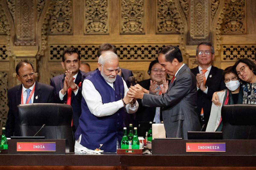 Perdana Menteri India Narendra Modi (kiri) dan Presiden Joko Widodo bersalaman saat penyerahan tongkat keketuaan G20 pada KTT G20 di Nusa Dua, Bali, 16 November 2022. 