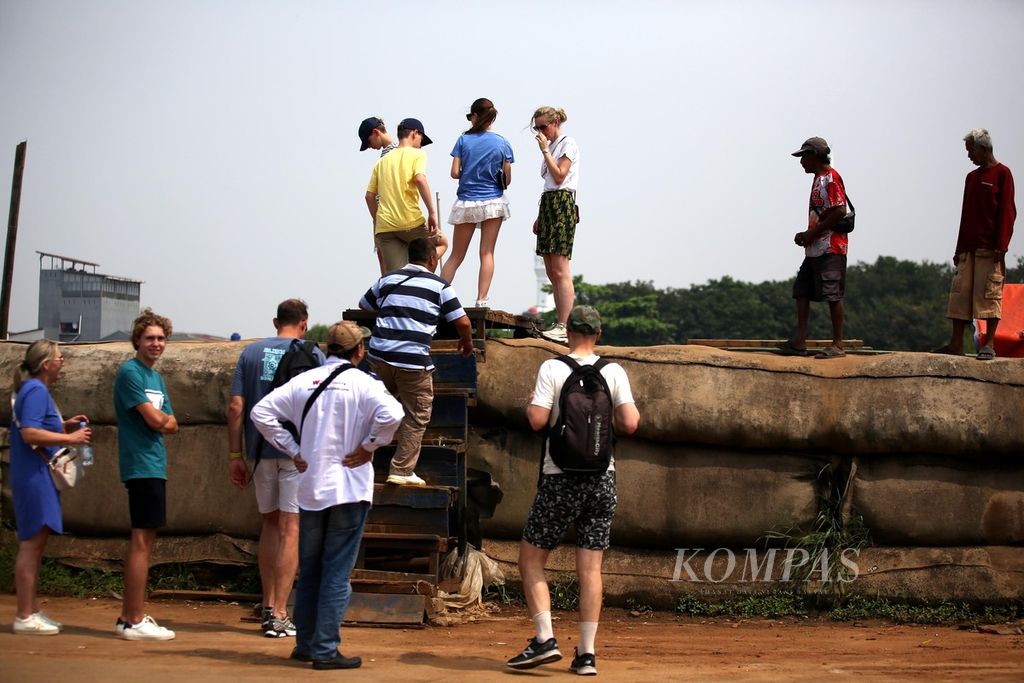 Turis asing mengeksplorasi kawasan Pelabuhan Sunda Kelapa, Pademangan, Jakarta, Minggu (14/7/2024).  