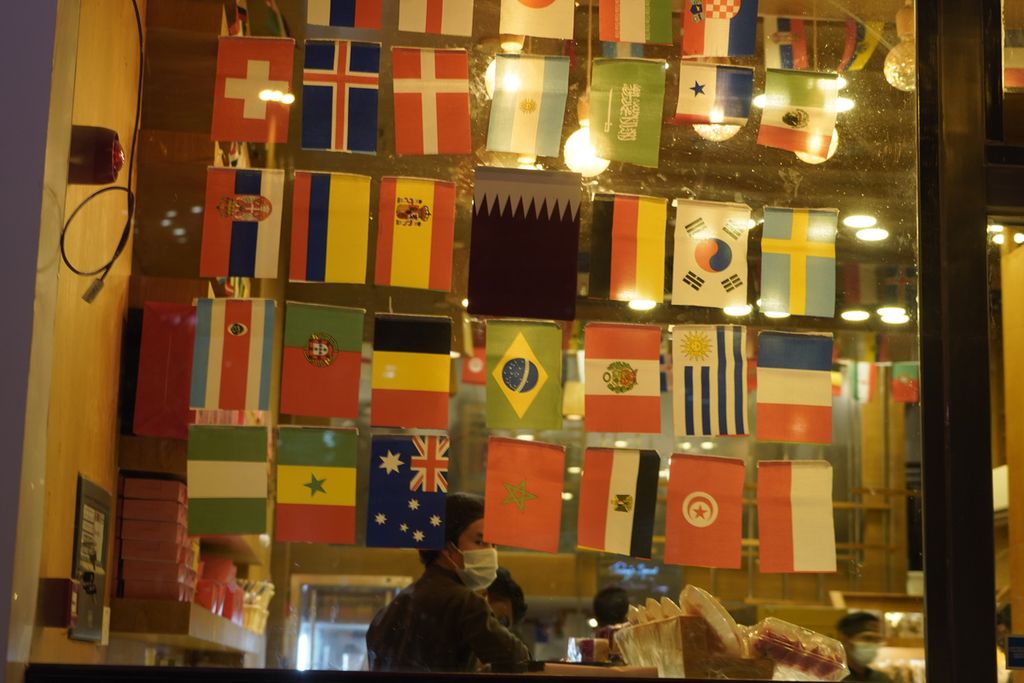 Toko-toko di Doha, Qatar, memajang bendera-bendara peserta Piala Dunia 2022 sebagai hiasan (16/11/2022). Penjualan <i>merchandise </i>seperti bendera atau kostum peserta World Cup menjadi salah satu lini perputaran ekonomi Piala Dunia. 