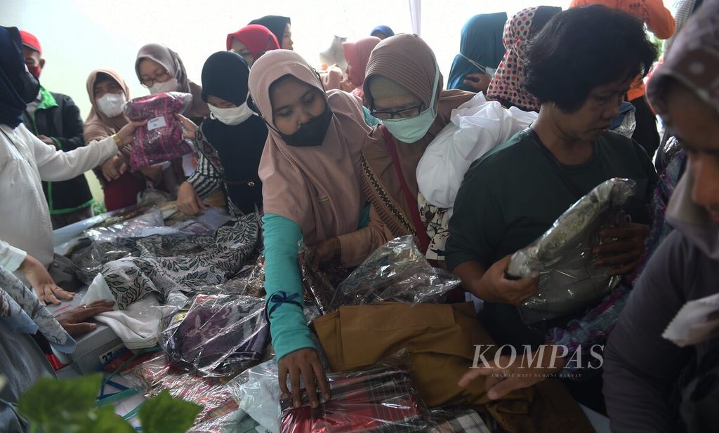 Warga berebut memilih sejumlah barang yang dijual saat Ramadhan Garage Sale di Gedung PKK Surabaya, Surabaya, Jawa Timur, Kamis (6/4/2023). 