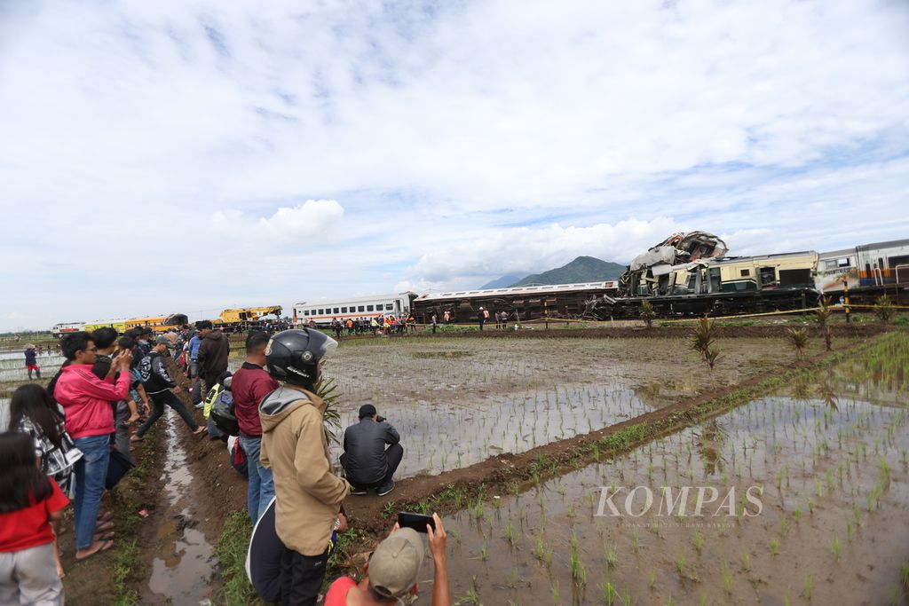 Warga menonton proses penangangan tabrakan Kereta Api Turangga relasi Surabaya Gubeng-Bandung dengan Commuter Line Bandung Raya di KM 181+700 petak jalan antara Stasiun Haurpugur-Stasiun Cicalengka, Jumat (5/1/2024).