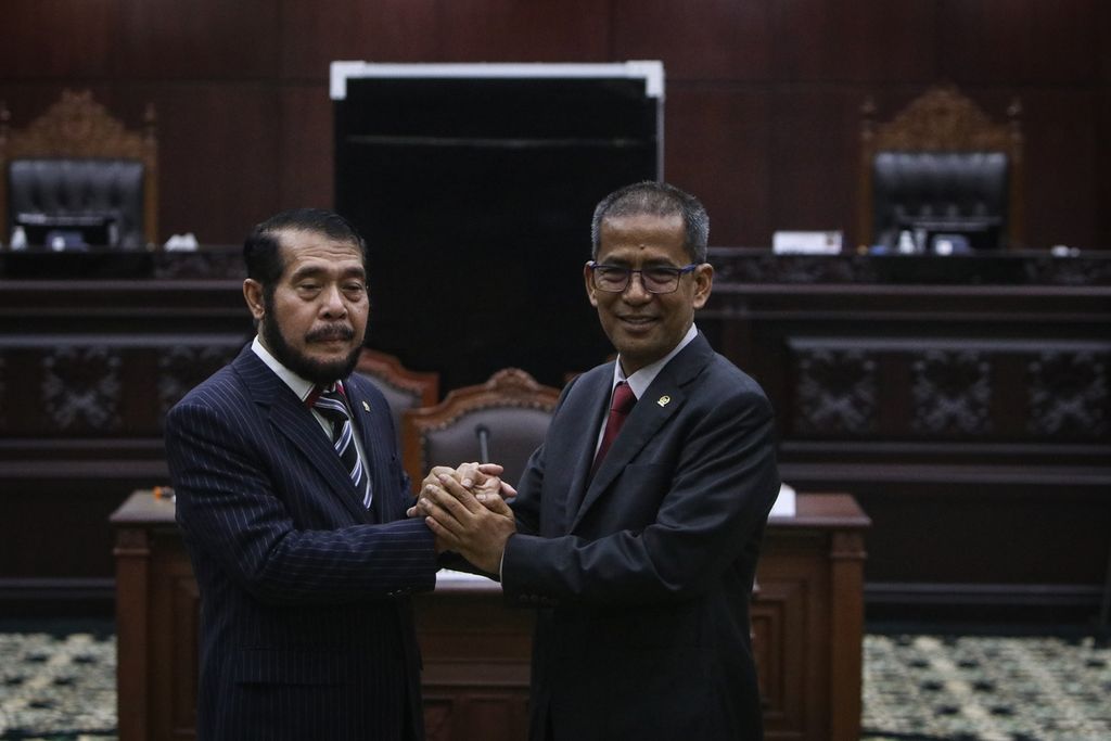 Ketua Mahkamah Konstitusi terpilih Anwar Usman (kiri) dan Wakil Ketua Mahkamah Konstitusi terpilih Saldi Isra (kanan) berjabat tangan setelah rapat pleno pemilihan ketua dan wakil ketua Mahkamah Konstitusi periode 2023-2028 di Gedung Mahkamah Konstitusi, Jakarta, Rabu (15/3/2023).