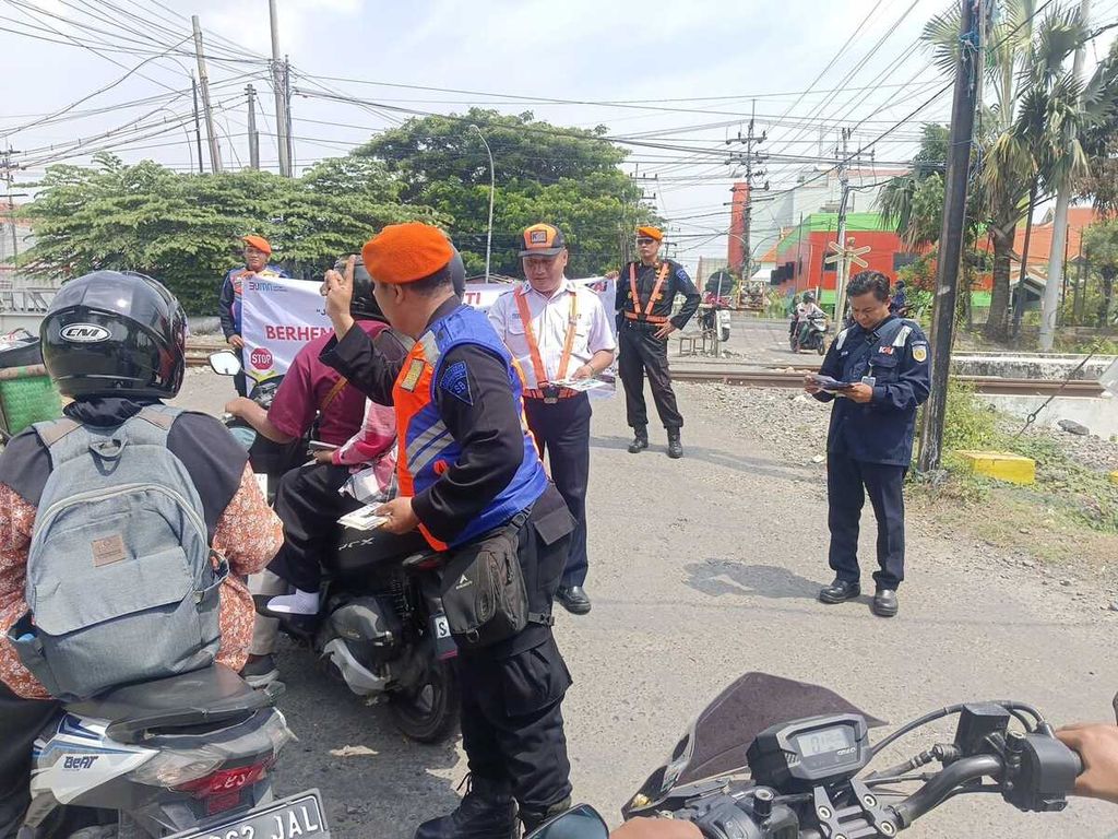 Petugas PT KAI Daop 8 Surabaya melakukan sosialisasi di pelintasan kereta sebidang dan tidak berpenjaga di jalur ganda antara Stasiun Mojokerto-Stasiun Sepanjang, Sidoarjo, Jawa Timur, awal Desember 2023. 