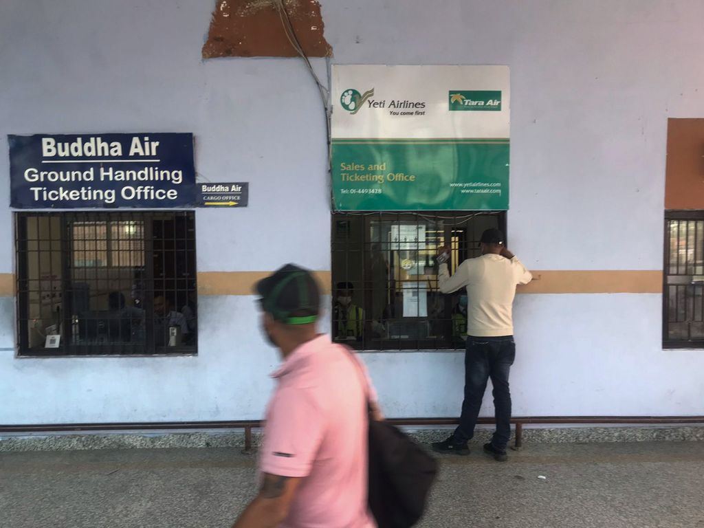 Seorang warga mencari informasi di depan loket maskapai Tara Airlines di Bandara Internasional di Kathmandu, Nepal, Minggu (29/5/2022). Sebuah pesawat yang dioperasikan oleh Tara Airlines dilaporkan hilang kontak beberapa saat sebelum mendarat di Jomson, Nepal. 