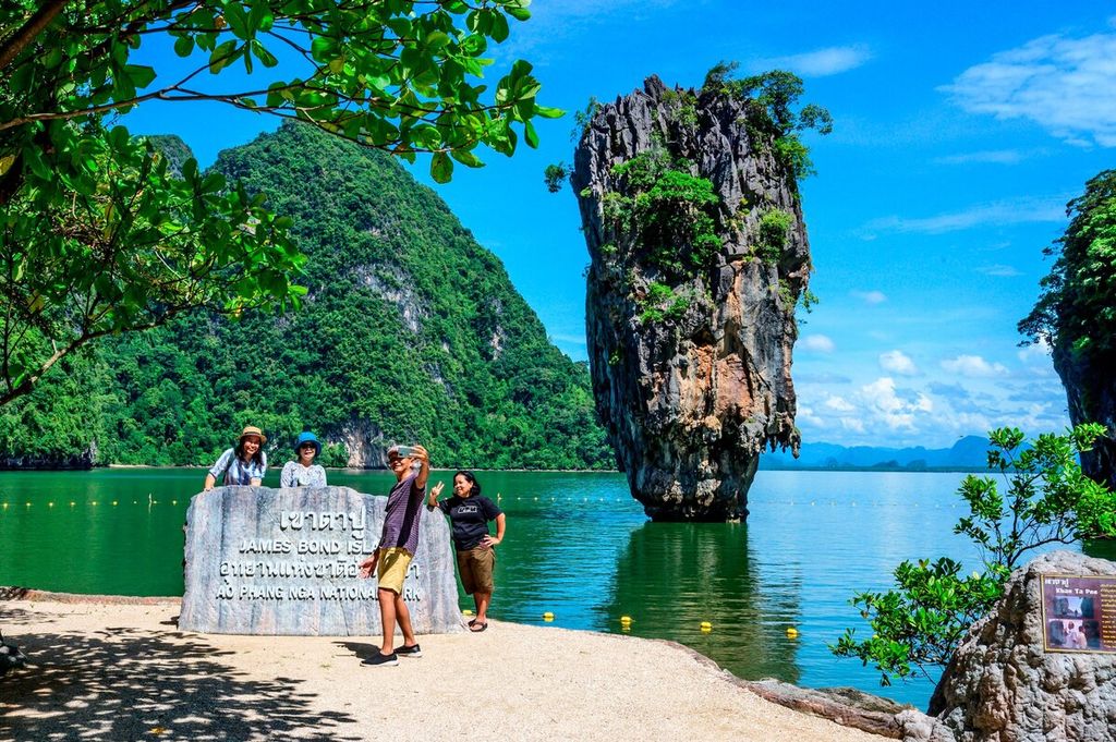 Turis berfoto di depan Pulau James Bond di Teluk Phang Nga di timur laut Phuket, Thailand, Sabtu (30/10/2021).  