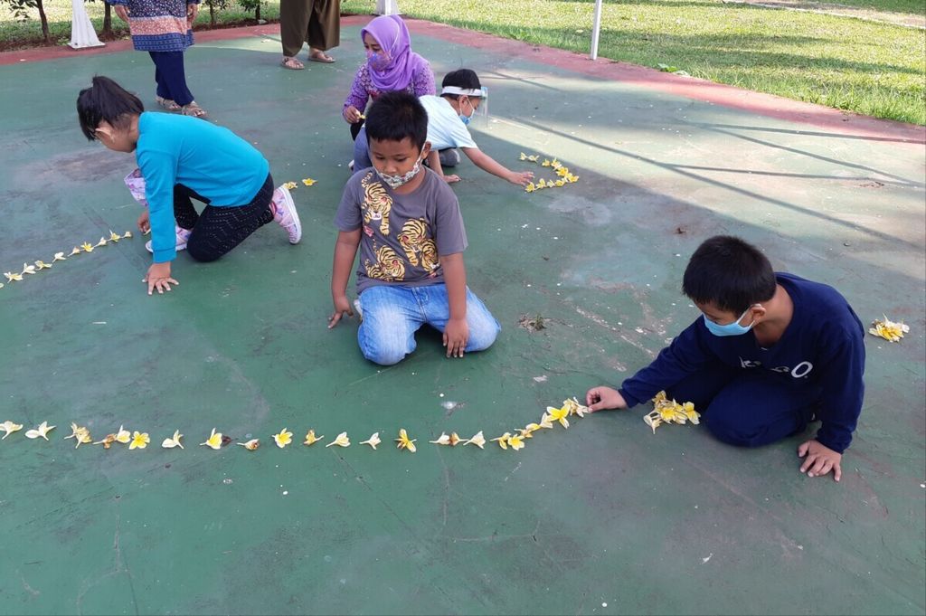 Dalam pendidikan Montessori, anak-anak usia dini diajak belajar secara konkret dengan alat bantu pembelajaran Di salah satu taman kanak-kanak di Jakarta Timur, anak-anak belajar mengenal angka dan huruf dengan memanfaatkan bunga kamboja yang gugur di halaman sekolah, Agustus 2020.