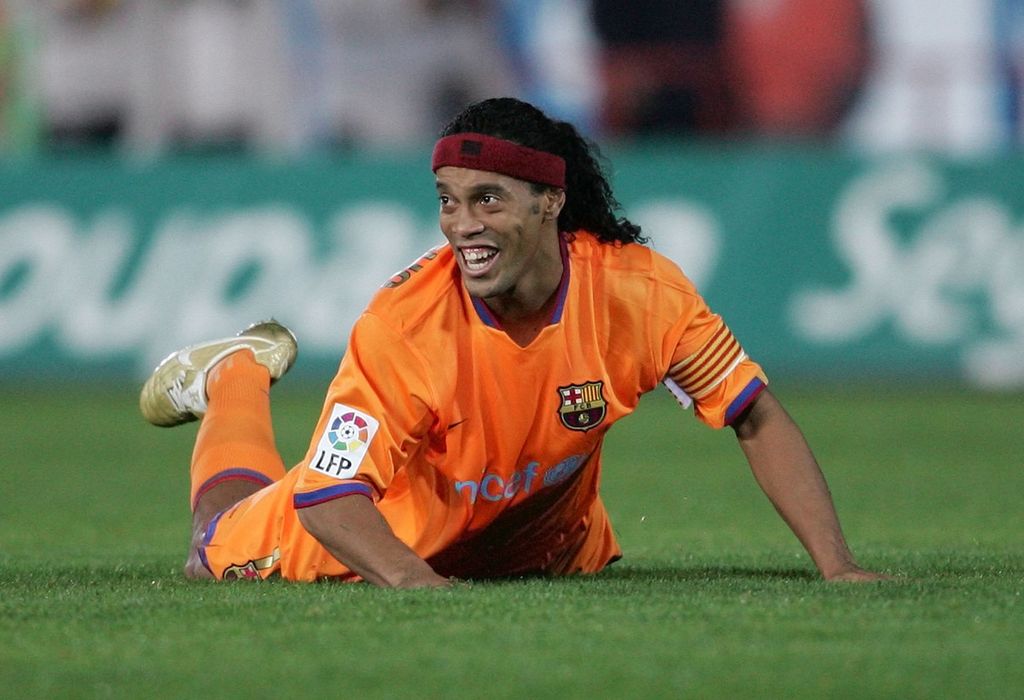 Meski terjatuh, bintang Barcelona, Ronaldinho, tetap menampakkan tawanya yang khas. Ronaldinho saat laga lawan Mallorca di Stadion Son Moix, Minggu (19/11/2006). 