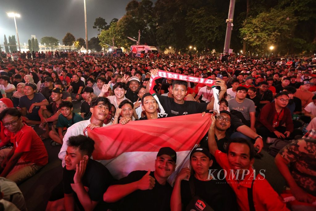 Suporter timnas Indonesia U-23 membawa atribut timnas saat melawan timnas Uzbekistan U-23 dalam babak semifinal Piala Asia U-23 2024 di kawasan Stadion Gelora Bung Karno, Jakarta, Senin (29/4/2024). Indonesia harus mengakui keunggulan Uzbekistan dengan skor 2-0.
