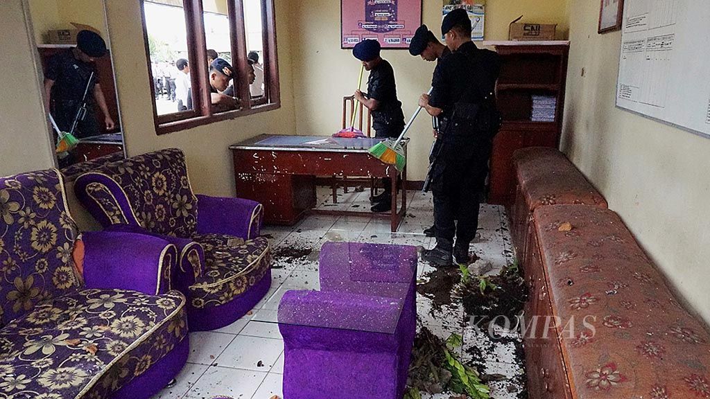 Aparat dari Brigade Mobil Polda Lampung membersihkan ruangan Polsek Tegineneng, Kabupaten Pesawaran, Lampung, yang diserang massa pada Jumat (17/3).