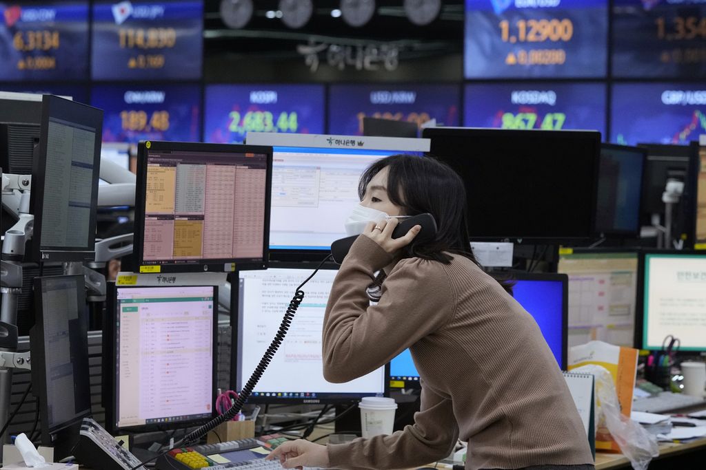 Seorang pialang tengah berkomunikasi melalui telepon di lantai bursa di markas besar Hana Bank di Seoul, Korea Selatan, Kamis (24/2/2022). Pasar saham di Asia, seiring dengan perdagangan di Wall Street, turun di tengah kekhawatiran invasi Rusia ke Ukraina.