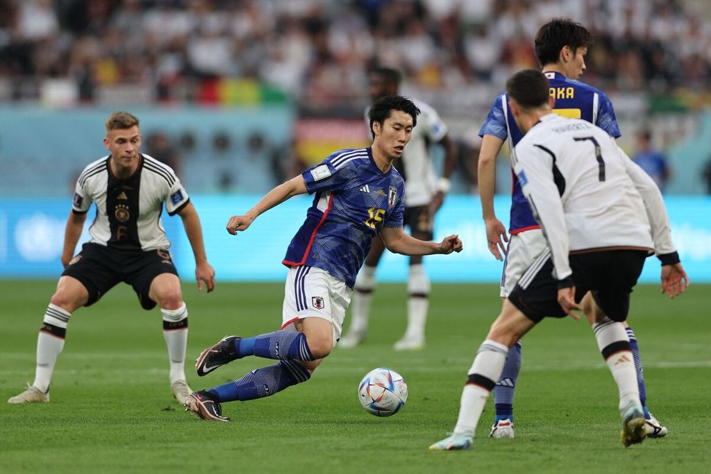 Pemain timnas Jepang Daichi Kamada (tengah) menggiring bola dengan diadang pemain timnas Jerman Kai Havertz pada laga penyisihan Grup E Piala Dunia di Stadion Khalifa International, Doha, Qatar, Rabu (23/11/2022). Jepang menang 2-1 pada laga itu. 