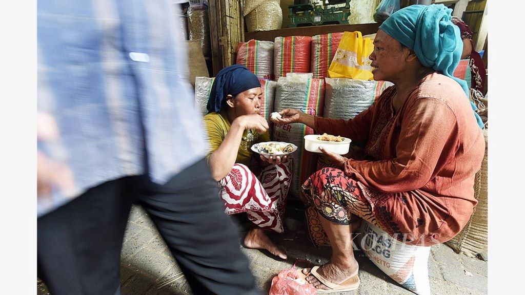 Buruh angkut perempuan makan saat istirahat di Pasar Pabean Surabaya, Jawa Timur, Rabu (20/4/2016). Mayoritas buruh angkut perempuan di pasar itu berasal dari Pulau Madura dan bekerja untuk membantu perekonomian keluarga. 