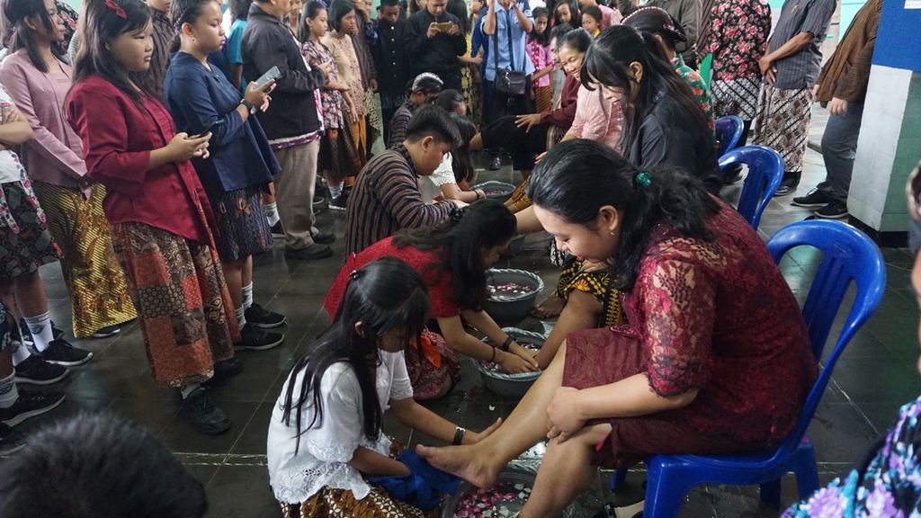 Murid membasuh kaki gurunya di SMP Pius, Cilacap, Jawa Tengah, Senin (25/11/2019). Guru dan murid saling bergantian membasuh kaki dalam peringatan Hari Guru Nasional sebagai simbol kerendahan hati dan saling menghormati.