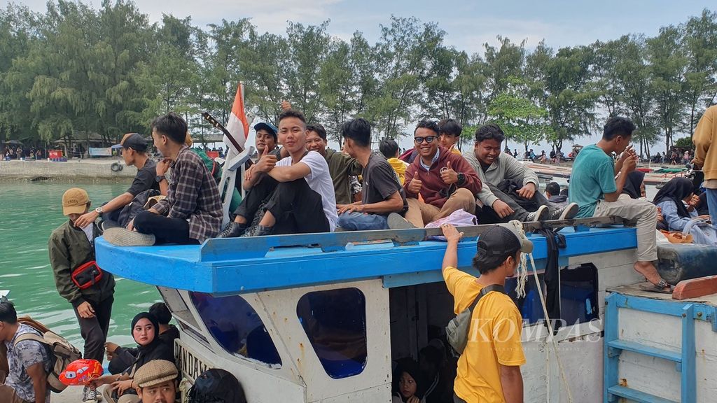 Para wisatawan menunggu kapal bersandar di Dermaga Pulau Pari, Kepulauan Seribu, Jakarta, Minggu (14/4/2024).