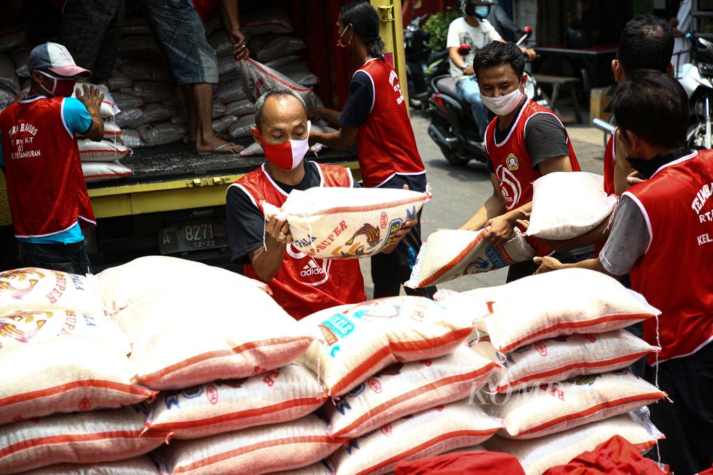Warga bergotong royong menurunkan paket bantuan sosial Covid-19 presiden yang disalurkan melalui Kementerian Sosial di Kelurahan Petamburan, Tanah Abang, Jakarta Pusat, Selasa (29/9/2020).