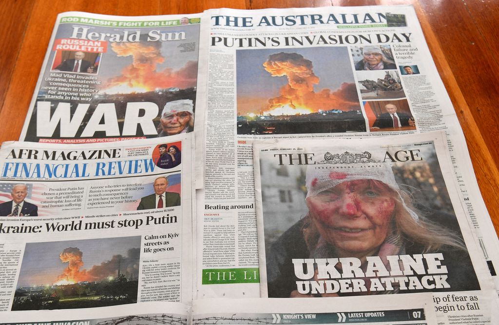 This photo illustration taken in Melbourne on February 25, 2022 shows front pages of newspapers reporting on the Russian invasion of Ukraine. 