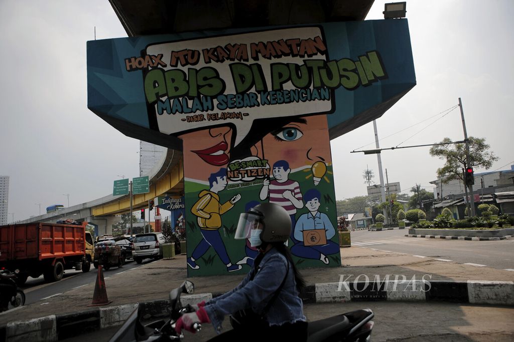 Warga melintasi mural berisi anjuran warga untuk hati-hati dengan hoaks di jalan layang Rawa Panjang, Kota Bekasi (11/6/2021). Penyebaran berita hoaks dan perundungan siber yang tinggi menyebabkan Indonesia menjadi salah satu negara dengan tingkat keadaban yang rendah di dunia maya.