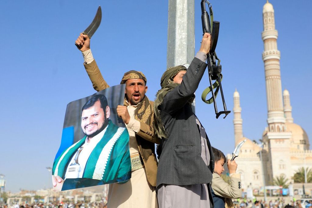 Pengunjuk rasa, sambil memegang poster foto Pemimpin Kelompok Houthi, Abdul Malik al-Houthi (kiri), berdemonstrasi menentang serangan Amerika Serikat dan Inggris di Sana’a, Yaman, Jumat (12/1/2024). 