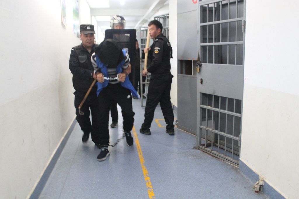 Kepolisian Xinjiang sedang melakukan latihan penanganan tahanan yang berupaya kabur atau penanganan huru-hara di salah satu kemah indoktrinasi di Tekes, Xinjiang, China. Foto ini diduga berasal dari tahun 2018 dan diretas dari data Kepolisian China. Foto-foto tersebut lalu diakses oleh Yayasan Peringatan Korban Komunisme (VCMF) di Amerika Serikat dan dipublikasikan oleh Konsorsium Jurnalis Investigatif Internasional (ICIJ) pada 24 Mei 2022. 