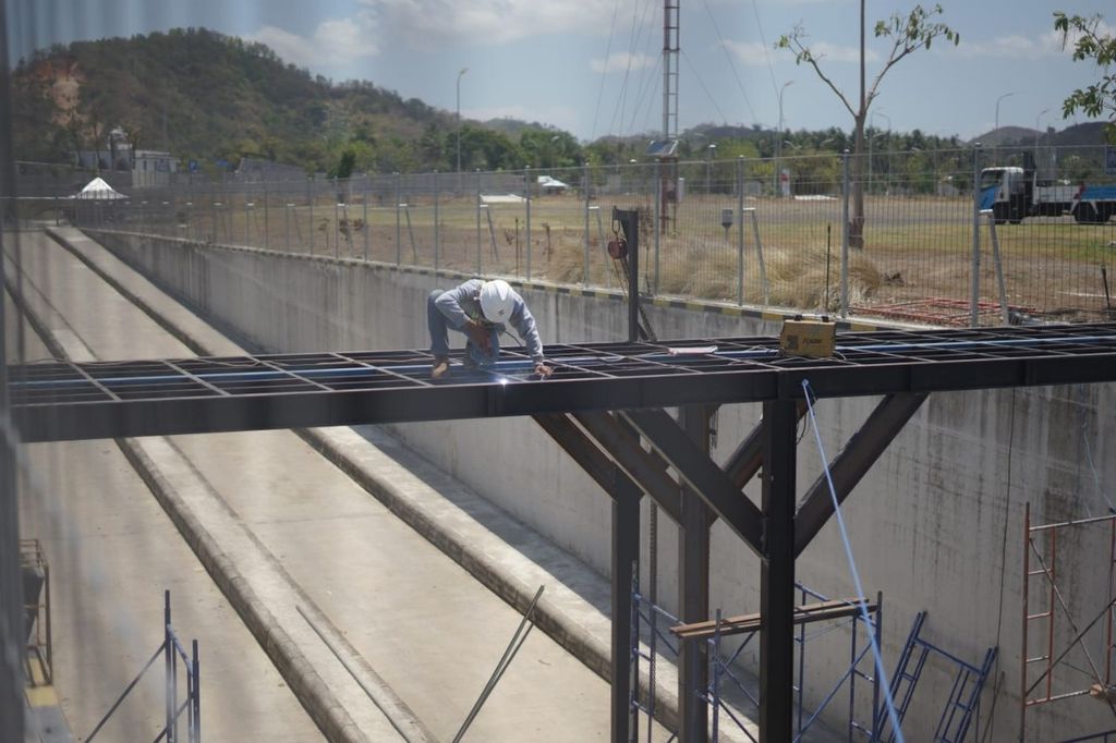 Petugas membangun jembatan permanen yang akan menghubungkan area VIP Deluxe dengan area Royal Box atau <i>paddock</i> di Sirkuit Internasional Mandalika, Lombok Tengah, NTB, Rabu (27/9/2023).