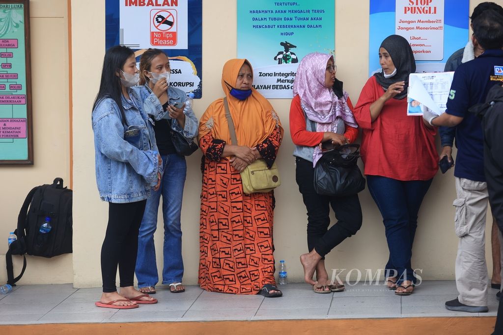 Keluarga korban kerusuhan di Stadion Kanjuruhan menunggu proses identifikasi jenazah di Instalasi Kedokteran Forensik Medikolegal, Rumah Sakit Saiful Anwar, Malang, Jawa Timur, Minggu (2/10/2022). 