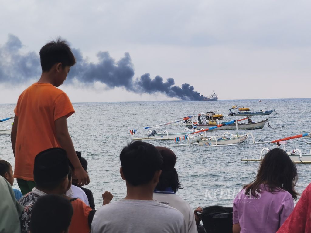 Warga memadati pantai untuk melihat Kapal MT Kristin yang terbakar di perairan barat Pulau Lombok, tepatnya di kawasan Pantai Ampenan, Kota Mataram, Nusa Tenggara Barat, Minggu (26/3/2023) sore. 