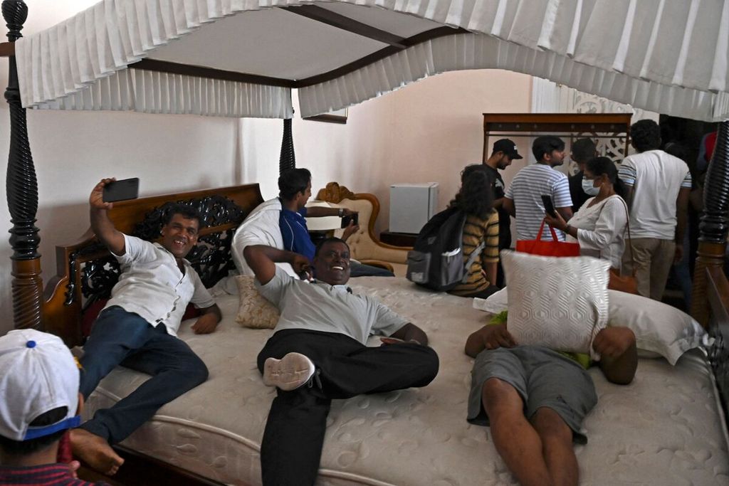 Para pengunjuk rasa bersantai di tempat tidur dalam istana kepresidenan Sri Lanka di Colombo, Sri Lanka, Minggu (10/7/2022). Aksi penyerbuan dan pendudukan istana kepresidenan itu berlangsung sejak Sabtu (9/7/2022). 