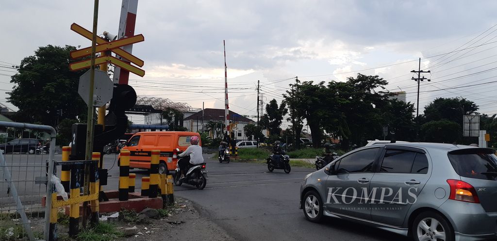 Sejumlah pengendara sepeda motor dan mobil melintas di pelintasan sebidang kereta api di dekat Stasiun Waru, Sidoarjo, Jawa Timur, Kamis (5/1/2023). Pelintasan sebidang merupakan salah satu lokasi rawan kecelakan lalu lintas. 