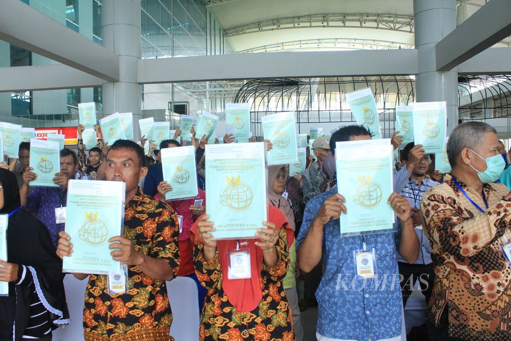 Warga menunjukkan sertifikat tanah dalam acara Penyerahan Sertifikat Tanah Program Pendaftaran Tanah Sistematis Lengkap di Bandara Internasional Jawa Barat Kertajati di Kabupaten Majalengka, Jumat (26/1/2024). 