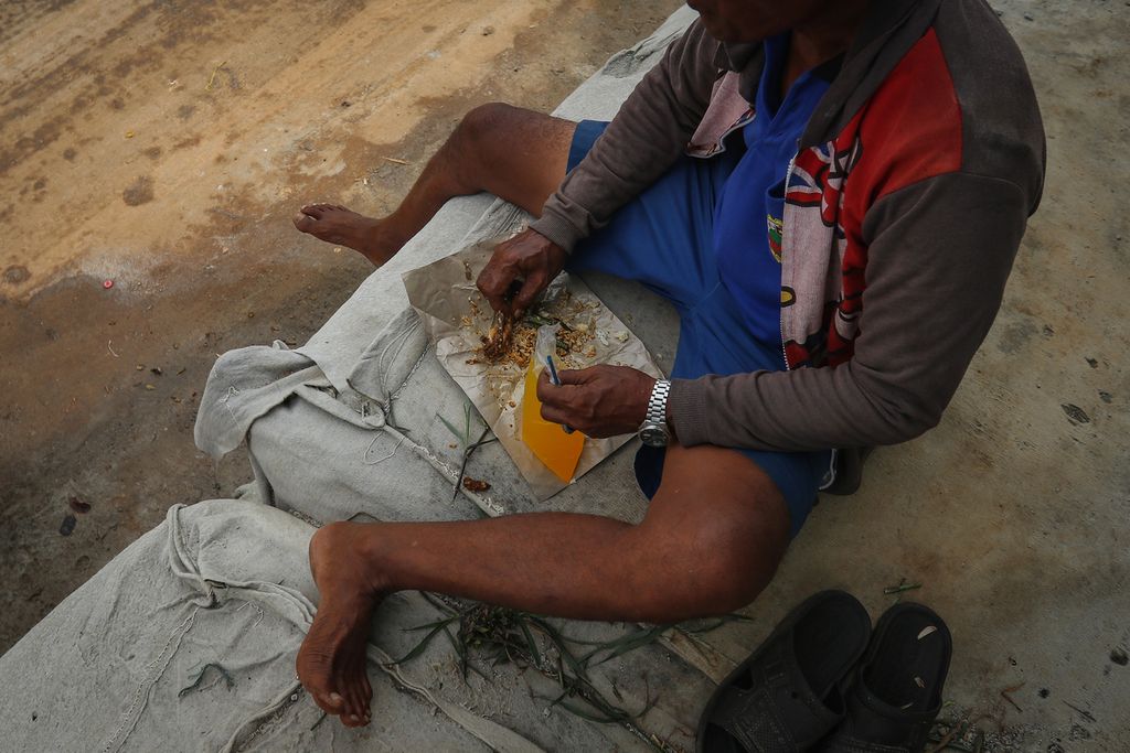  A worker having lunch in an area of Sunda Kelapa Harbor, North Jakarta, Friday (9/12/2022). Approximately 183.7 million people or 68 percent of Indonesia's population are unable to meet their daily nutritional needs.