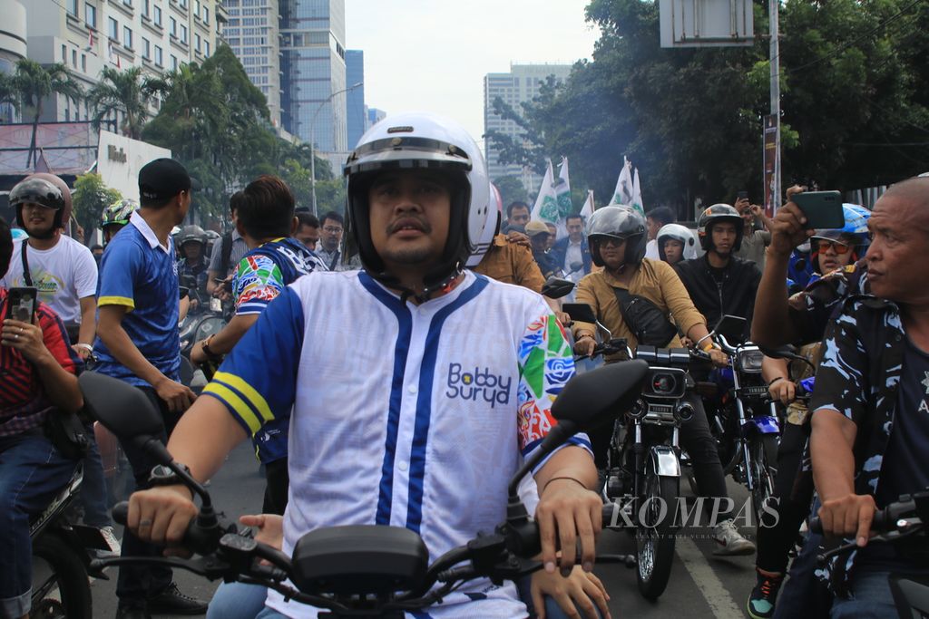 Bobby Afif Nasution dan Surya mengendarai sepeda motor saat hendak mendaftar sebagai bakal calon gubernur dan wakil gubernur Sumatera Utara ke Komisi Pemilihan Umum Provinsi Sumatera Utara, di Medan, Rabu (28/8/2024). 