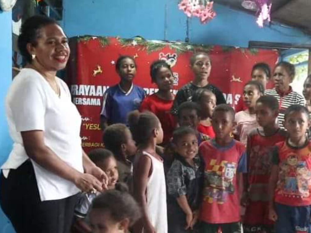 Michelle Kurisi Doga (kiri), perempuan aktivis Papua, berkegiatan bersama anak-anak, Desember 2022. Michelle dibunuh kelompok kriminal bersenjata pada 28 Agustus 2023 di Kabupaten Lanny Jaya, Papua Pegunungan.