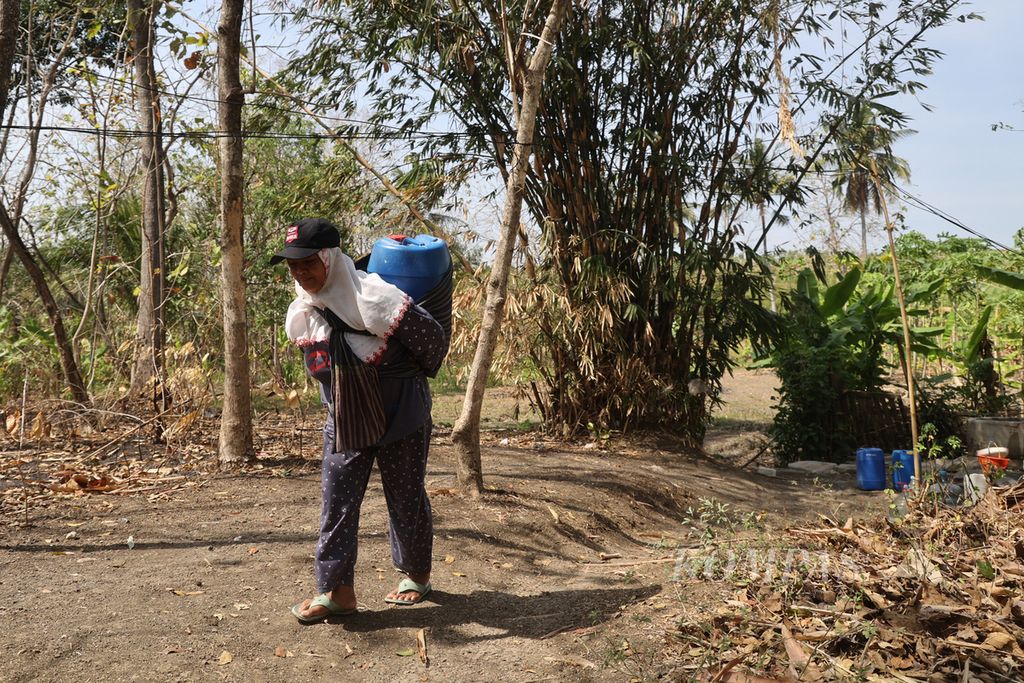 Rukini (42) mengambil air dari sumur di tepi ladang, di Dusun Bogor Krajan, Desa Bojong, Wonosegoro, Boyolali, Jawa Tengah, Senin (4/9/2023). Sumur tersebut diandalkan oleh warga yang terkena dampak kekeringan akibat kemarau. Sejak April lalu, warga bergantian mengambil air di sumur itu untuk keperluan sehari-hari. 