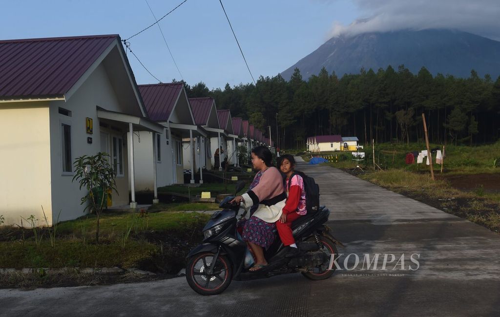 Warga mengantarkan anak ke sekolah di kompleks hunian tetap penyintas Erupsi Gunung Semeru tahun 2021 di Desa Sumbermujur, Kecamatan Candipuro, Kabupaten Lumajang, Jawa Timur, Rabu (7/12/2022).