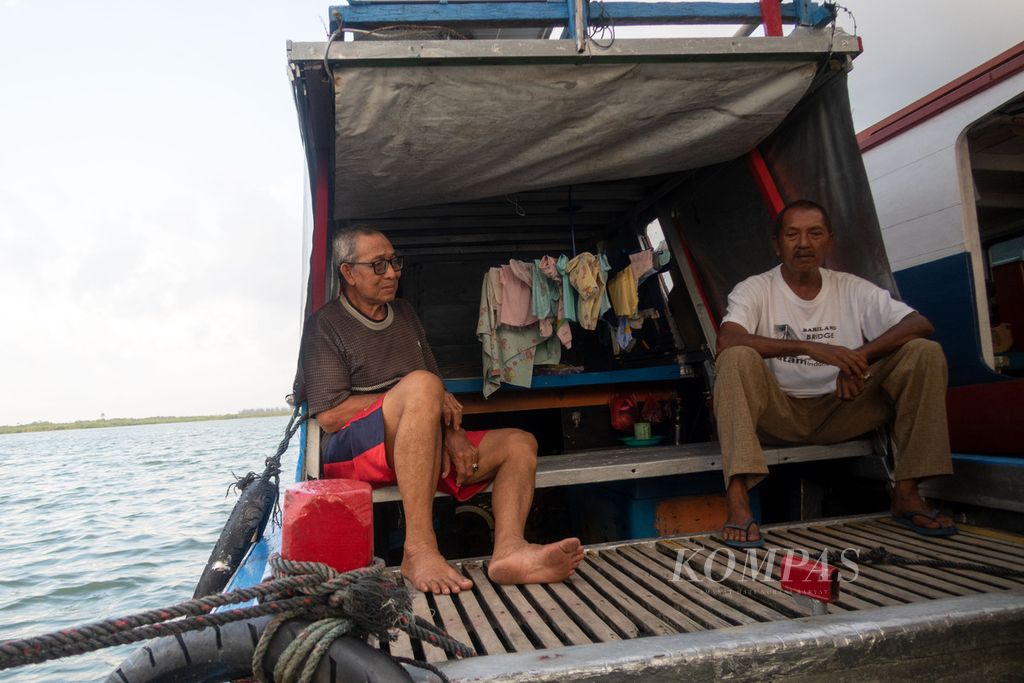 (Dari kanan ke kiri) Supardi (62) mengunjungi Syarief (71), salah satu korban longsor, yang memilih mengungsi di atas perahu di Pulau Serasan, Kabupaten Natuna, Kepulauan Riau, Jumat (10/3/2023).