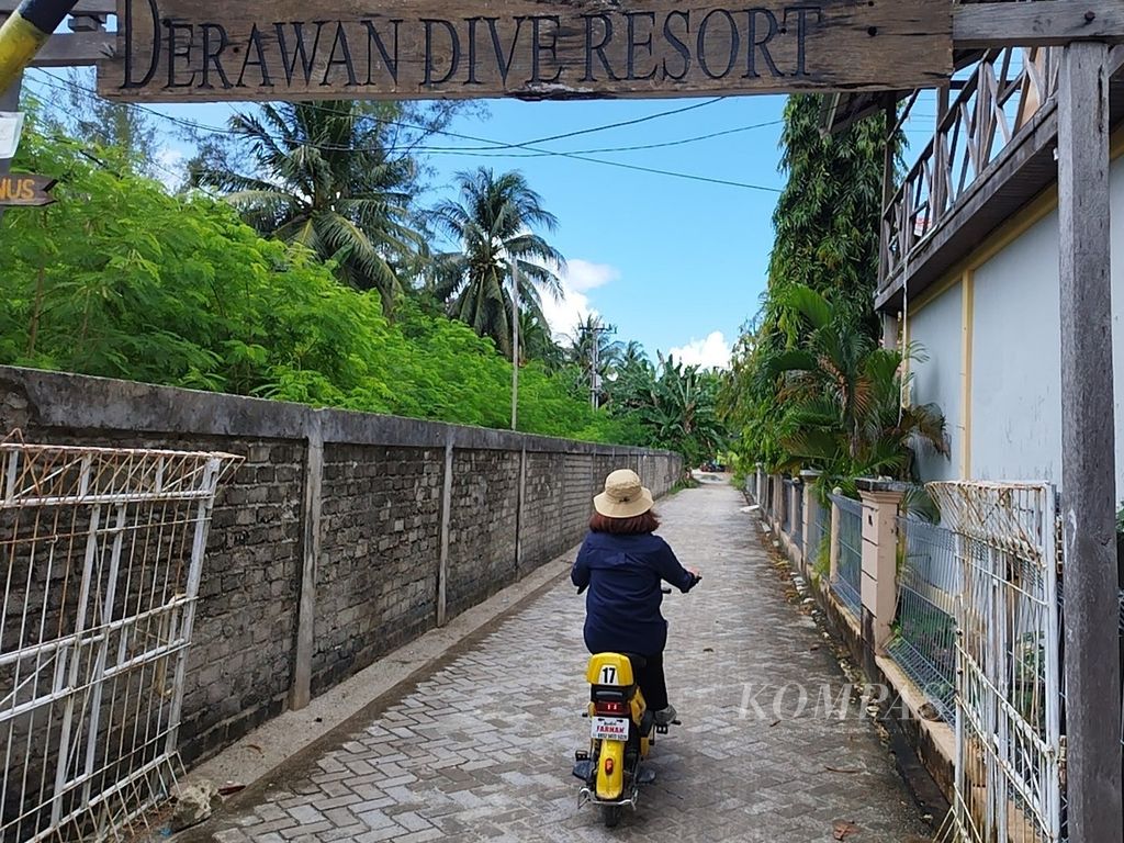 Wisatawan mengendarai sepeda listrik menuju kawasan resor Pulau Derawan, Kabupaten Berau, Kalimantan Timur, Minggu (25/2/2024).