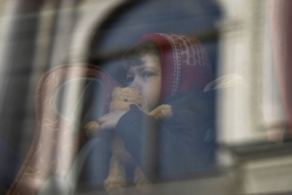Seorang anak yang mengungsi dari perang di Ukraina menunggu di dalam bus setelah tiba di stasiun kereta api Przemysl di Przemysl, Polandia, Selasa (15/3/2022). AP PHOTO/PETROS GIANNAKOURIS 